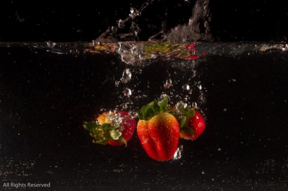 Strawberry dropping into water